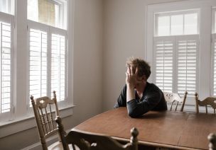 Photo of Man Leaning on Wooden Table