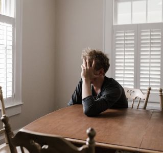 Photo of Man Leaning on Wooden Table